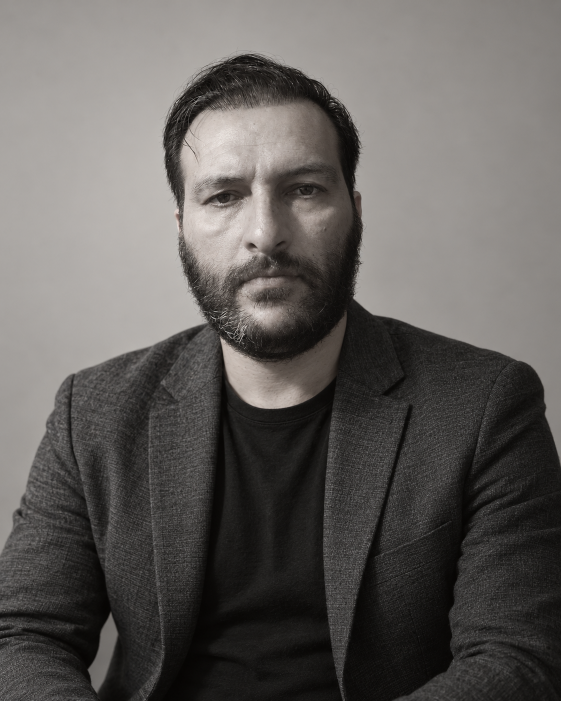 Ali Nojoumi in a dark jacket, photographed against a neutral background.