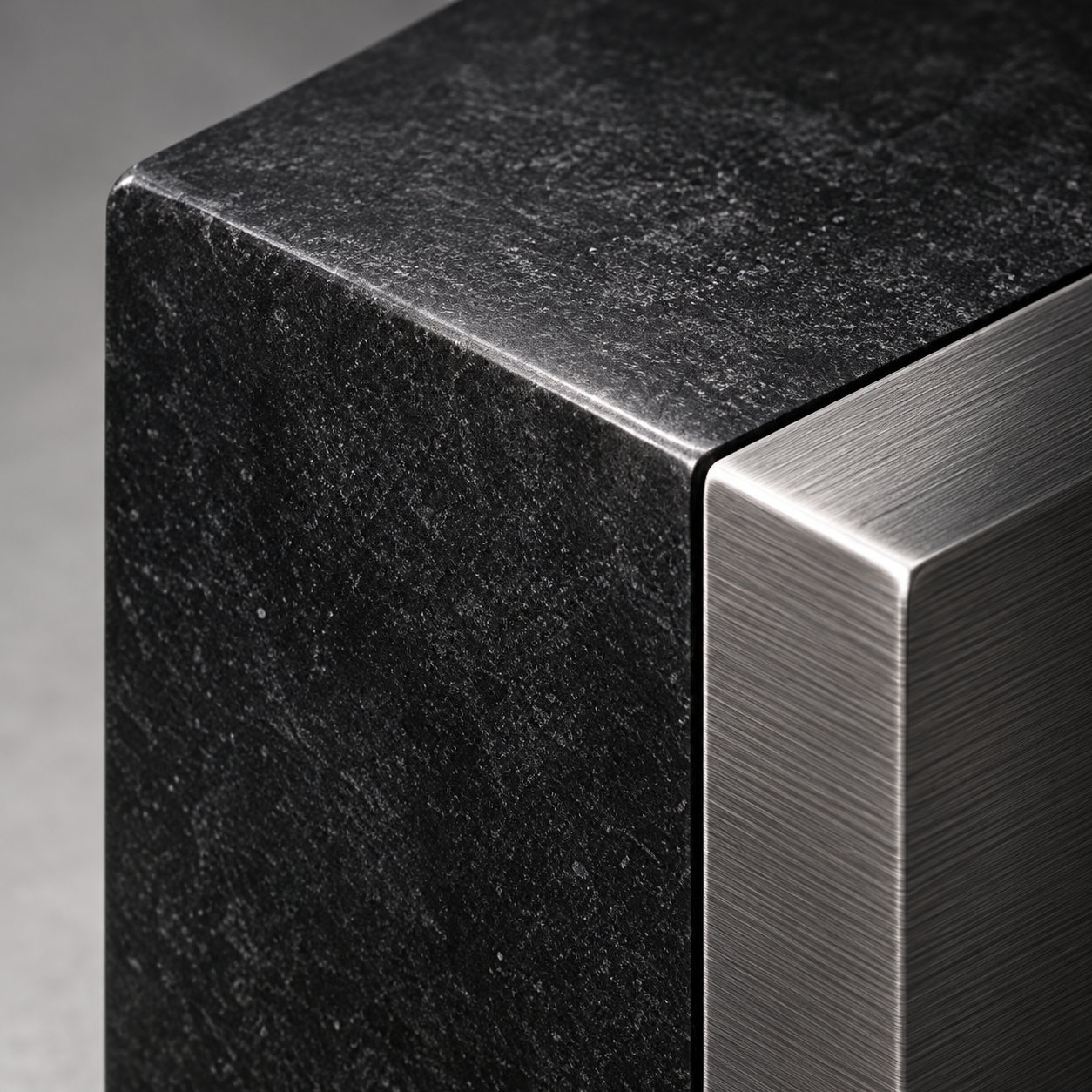 Conceptual close-up of a dark stone and brushed metal form.